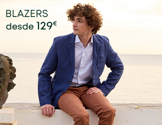 Hombre con blazer azul marino y jersey beige con el texto 'Blazers desde 129€'