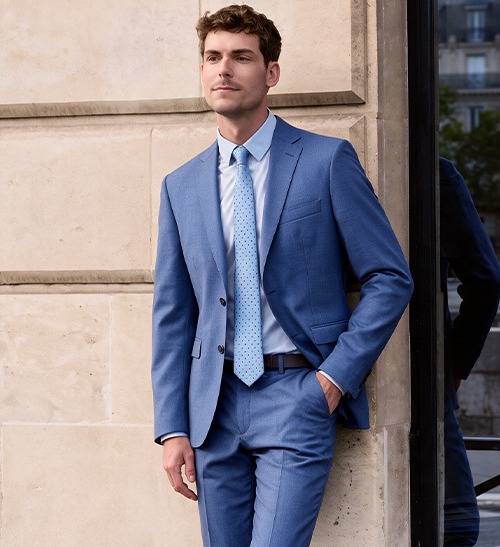 Man wearing a blue suit with a light shirt and a dotted tie