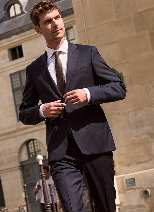 Man wearing a navy suit with a tie