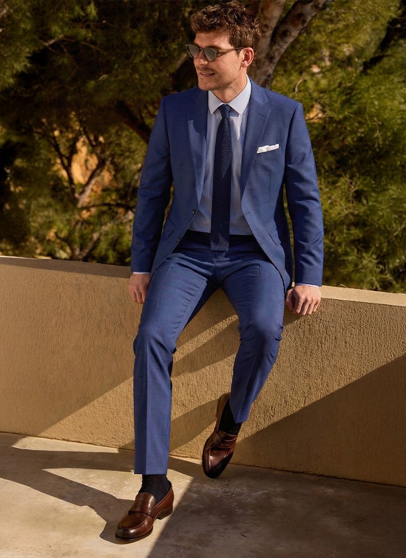 Man wearing a suit in an urban formal setting.