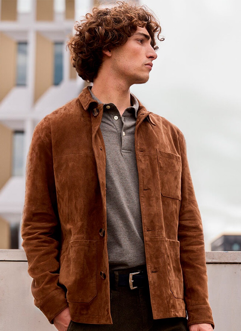 Man wearing a tan suede leather jacket over a grey polo shirt