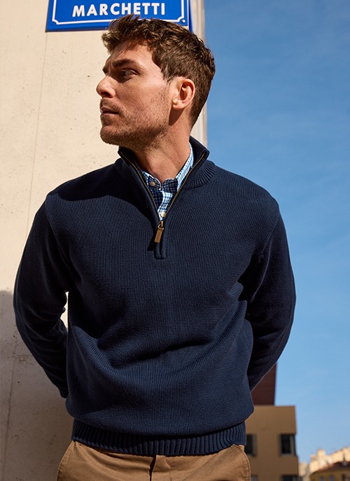 Man wearing a navy blue half-zip jumper in a smart casual look.