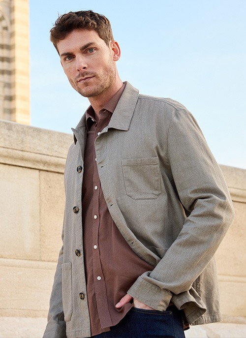Man wearing a lightweight green jacket in an urban style.
