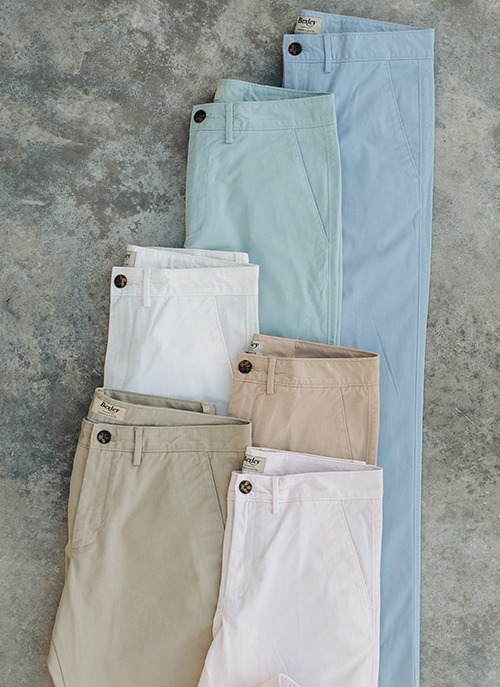 Collection of men's pastel-coloured chino trousers, perfect for an elegant summer look